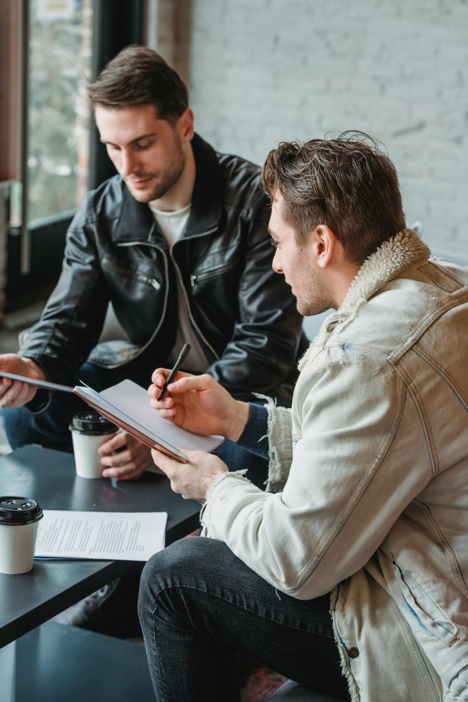 Dos hombres hablando y tomando café